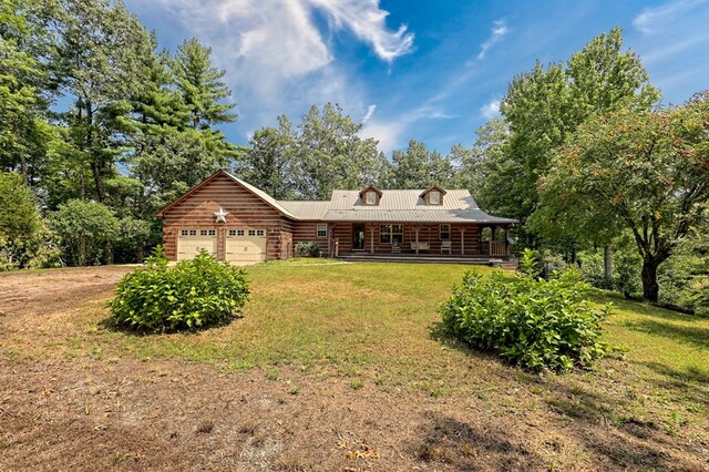 rear view of house with a garage, a yard, and a porch