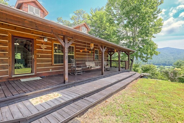 deck featuring a mountain view and a yard