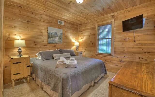 bedroom featuring wood ceiling, visible vents, wood walls, and light carpet