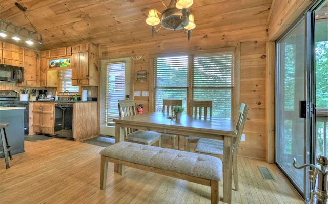 dining area with light wood-style flooring, wood ceiling, and a healthy amount of sunlight