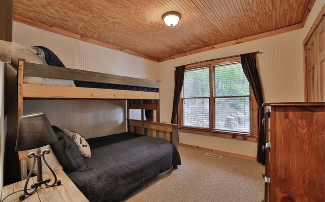 bedroom featuring carpet flooring, wood ceiling, and baseboards