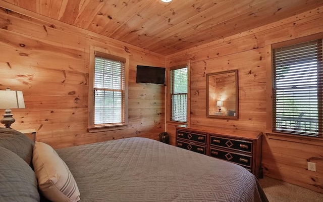 bedroom with wooden ceiling, wooden walls, and multiple windows