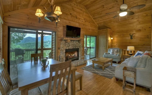 living area with a fireplace, wooden walls, wood ceiling, and wood-type flooring