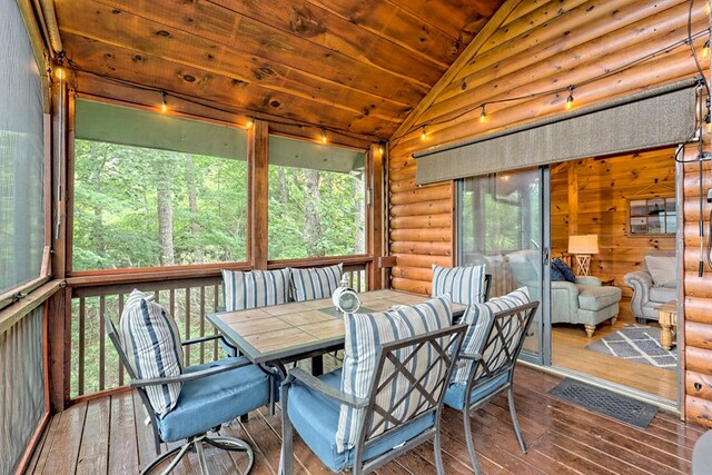 sunroom / solarium with lofted ceiling, wood ceiling, and a healthy amount of sunlight