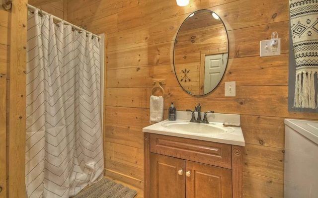 full bathroom with vanity, a shower with shower curtain, and wood walls