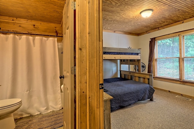 carpeted bedroom with wood ceiling