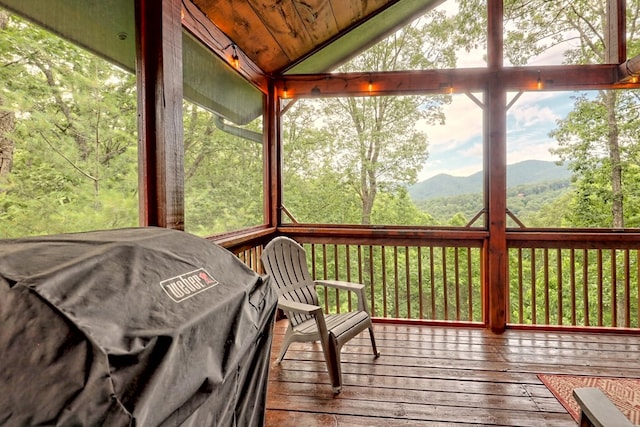 unfurnished sunroom featuring a wealth of natural light, a mountain view, and lofted ceiling