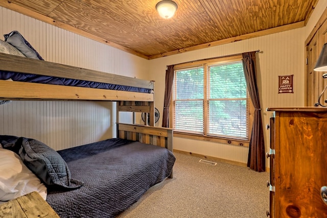 carpeted bedroom with visible vents and wooden ceiling