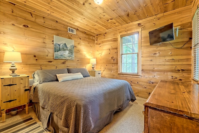 bedroom with wooden walls, wood ceiling, visible vents, and light carpet