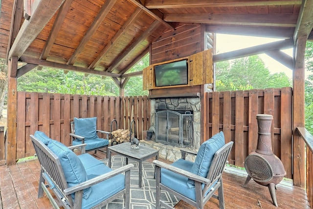 view of patio / terrace with an outdoor living space with a fireplace and fence