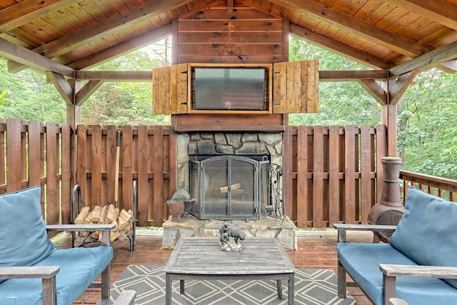 exterior space featuring an outdoor stone fireplace and fence