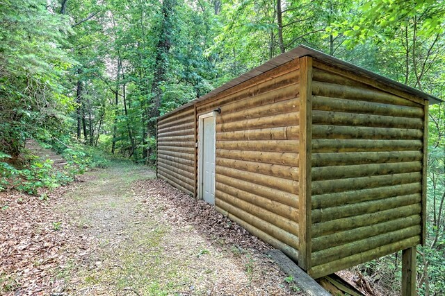 view of outdoor structure with an outbuilding and a view of trees