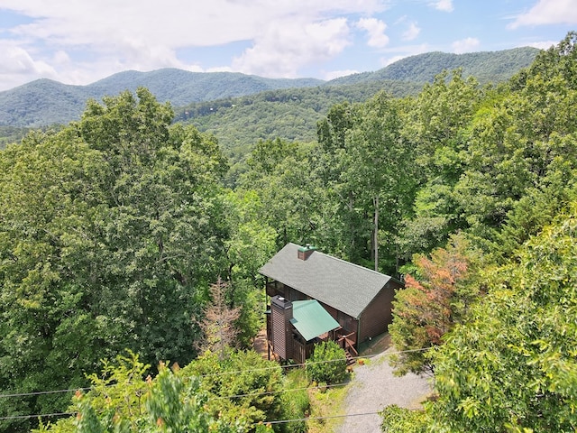 drone / aerial view with a wooded view and a mountain view