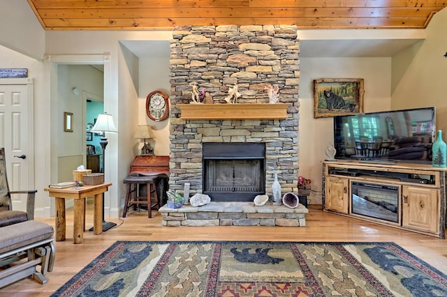 living room with a stone fireplace, wooden ceiling, and light hardwood / wood-style flooring