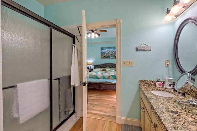 bathroom with ceiling fan, vanity, wood-type flooring, and an enclosed shower