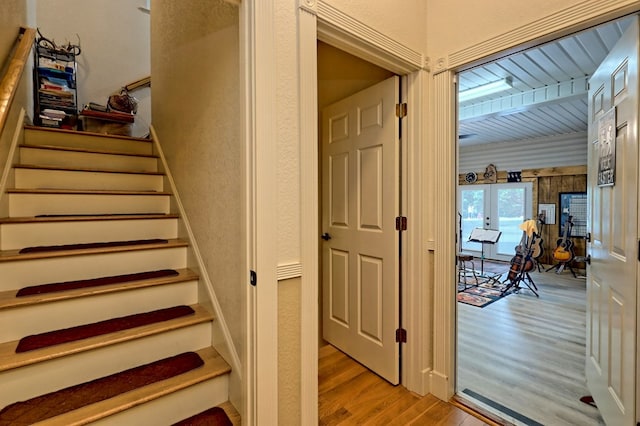 staircase with beam ceiling and hardwood / wood-style flooring