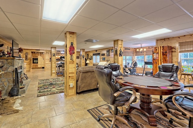 office area featuring a paneled ceiling, wood walls, and plenty of natural light