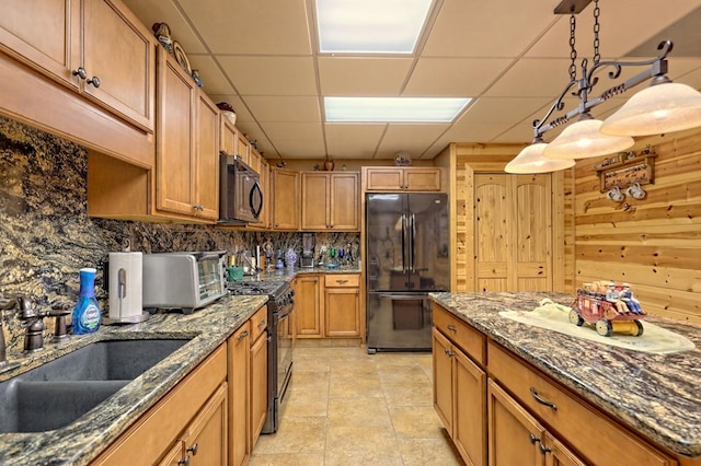 kitchen featuring sink, hanging light fixtures, tasteful backsplash, a paneled ceiling, and black appliances