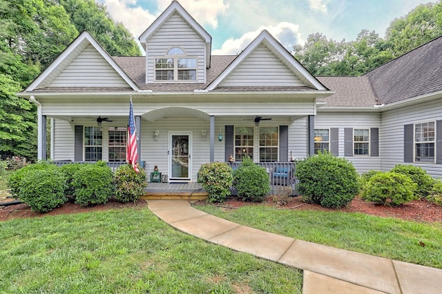 view of front of property featuring ceiling fan, a front lawn, and covered porch