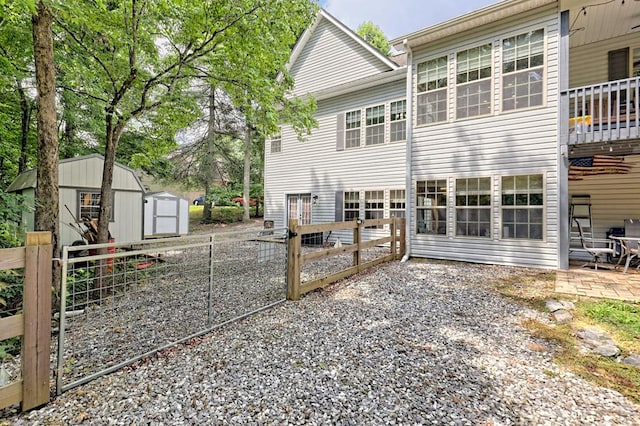 rear view of property featuring a patio and a shed