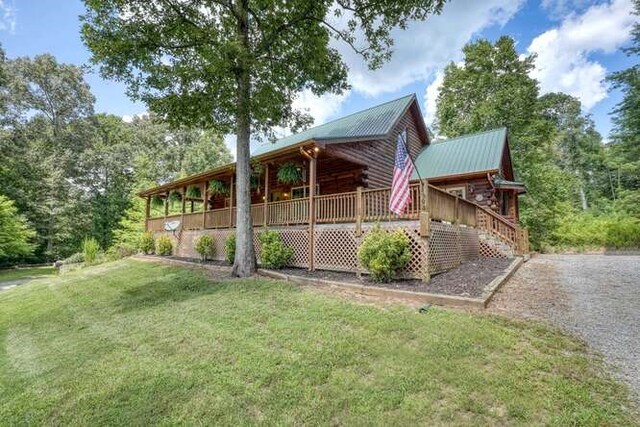 view of side of home featuring a yard and a wooden deck