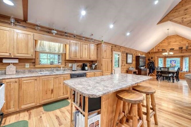 kitchen featuring a kitchen island, high vaulted ceiling, wood walls, light hardwood / wood-style floors, and sink