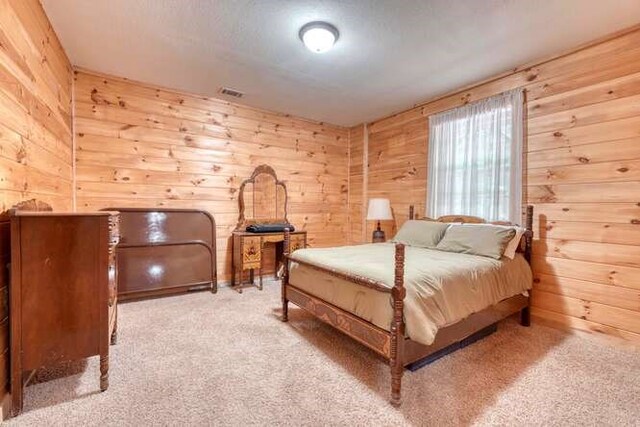 carpeted bedroom with wooden walls