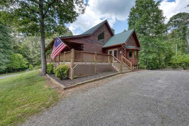 view of property exterior featuring a wooden deck and a lawn