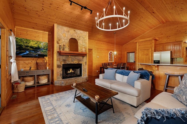 living room with wooden walls, a chandelier, wood ceiling, and light hardwood / wood-style flooring