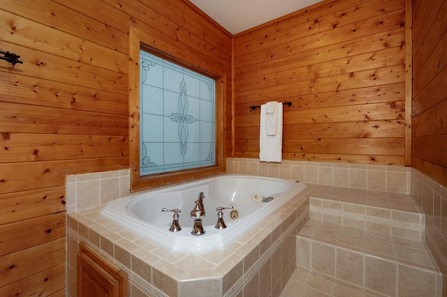 bathroom with tile patterned flooring, wooden walls, and a relaxing tiled tub