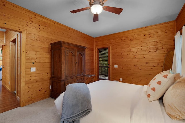 carpeted bedroom with wood walls and ceiling fan