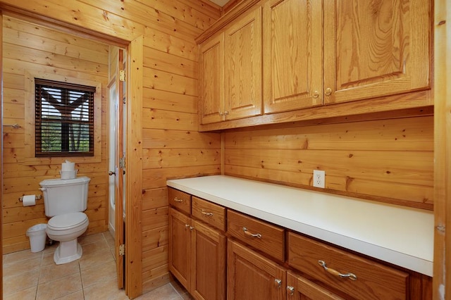 bathroom featuring tile patterned flooring, wood walls, toilet, and vanity