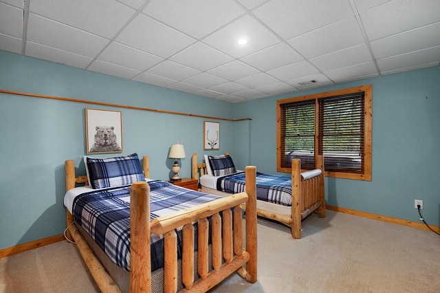 bedroom featuring carpet floors and a drop ceiling