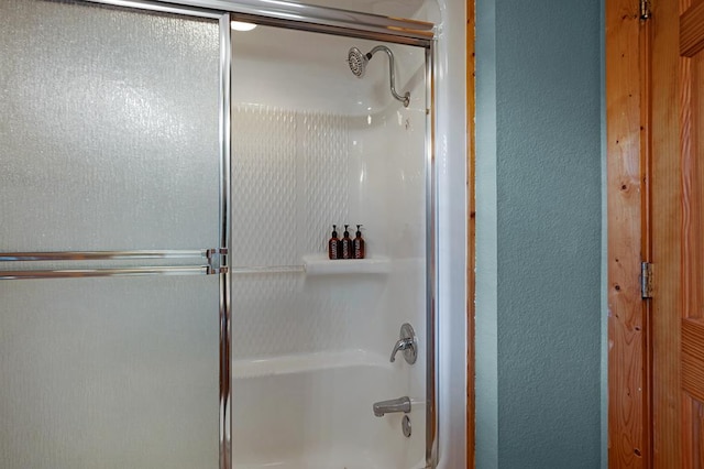 bathroom featuring bath / shower combo with glass door