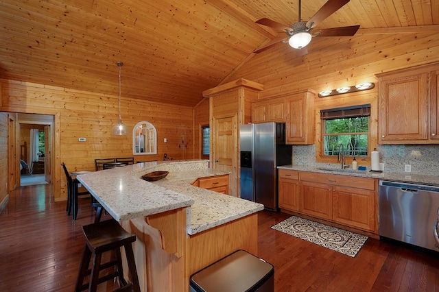 kitchen featuring sink, a kitchen island, wooden walls, high vaulted ceiling, and stainless steel appliances