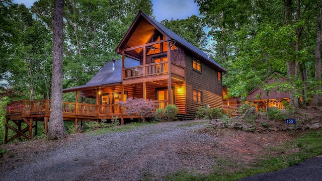 log cabin featuring a wooden deck and a balcony