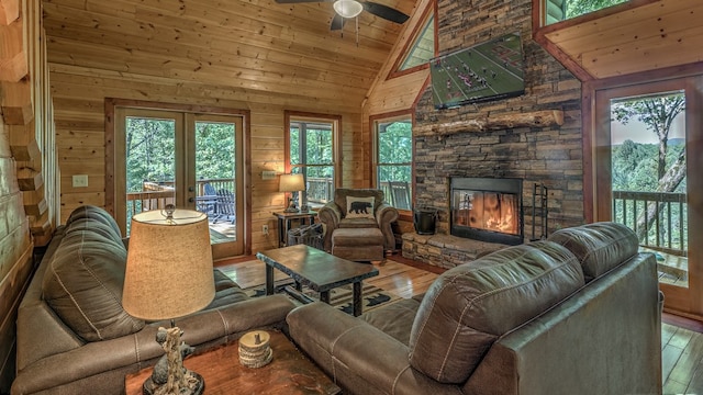 living room featuring wood walls, high vaulted ceiling, wooden ceiling, hardwood / wood-style flooring, and a fireplace