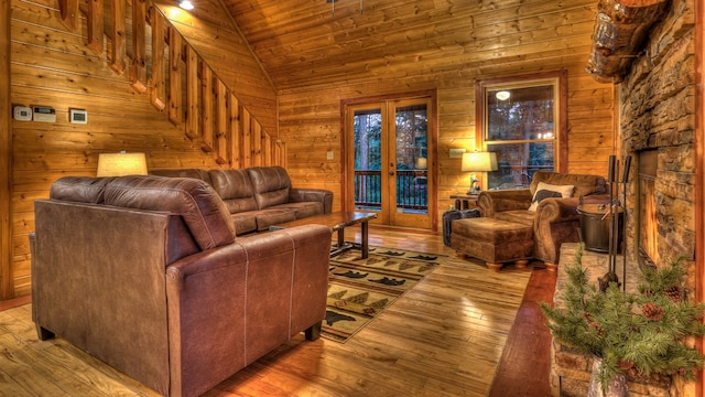 living room with vaulted ceiling, wooden walls, and light wood-type flooring