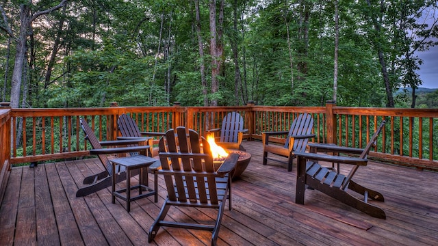 deck at dusk featuring a fire pit