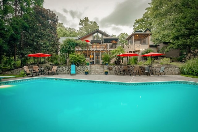 pool with a diving board and a patio area