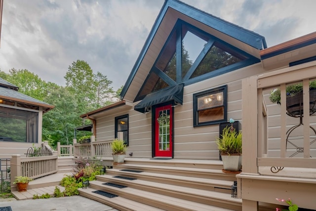 view of exterior entry featuring a wooden deck