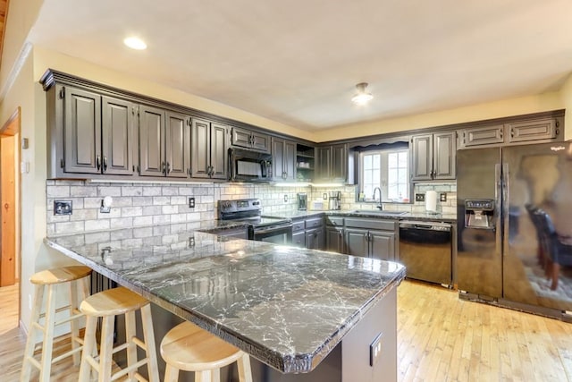 38 Smoky Mtn Rdg, Marble, NC 28905 - kitchen with black appliances, light wood-type flooring, a peninsula, dark stone counters, and backsplash