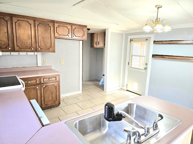 kitchen featuring sink, hanging light fixtures, an inviting chandelier, vaulted ceiling, and light tile patterned floors