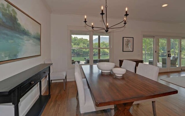 dining room with french doors, dark hardwood / wood-style flooring, ornamental molding, and a notable chandelier