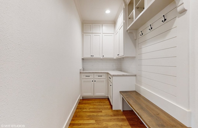 mudroom featuring ornamental molding and light hardwood / wood-style flooring