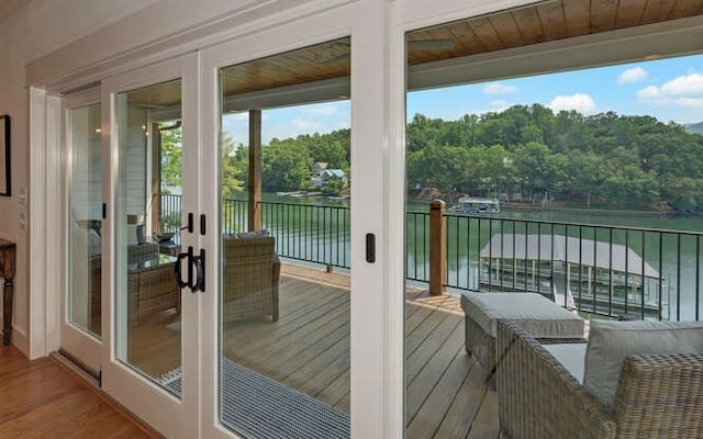 entryway with french doors, a water view, wood ceiling, and hardwood / wood-style floors