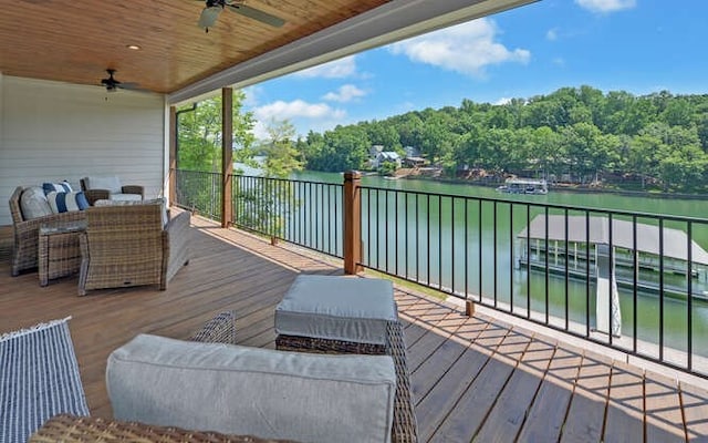 deck with ceiling fan and a water view