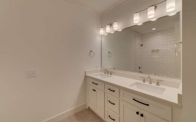 bathroom with tile patterned floors, vanity, a tile shower, and ornamental molding