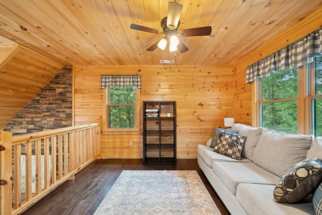 unfurnished living room featuring dark wood-type flooring, wooden ceiling, wooden walls, and ceiling fan