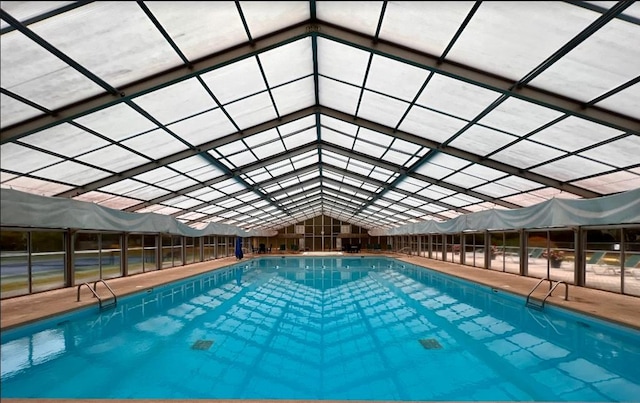 view of pool featuring glass enclosure